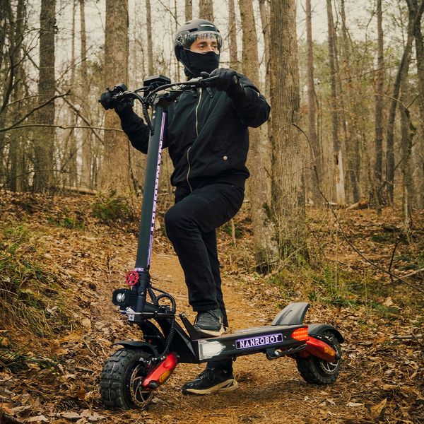 Utilizator pe trotineta electrică Nanrobot, pe o potecă forestieră